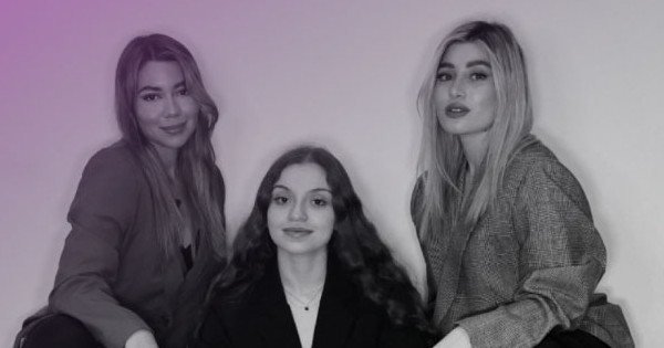 Tres creadoras de contenido sentadas junto a una computadora portátil